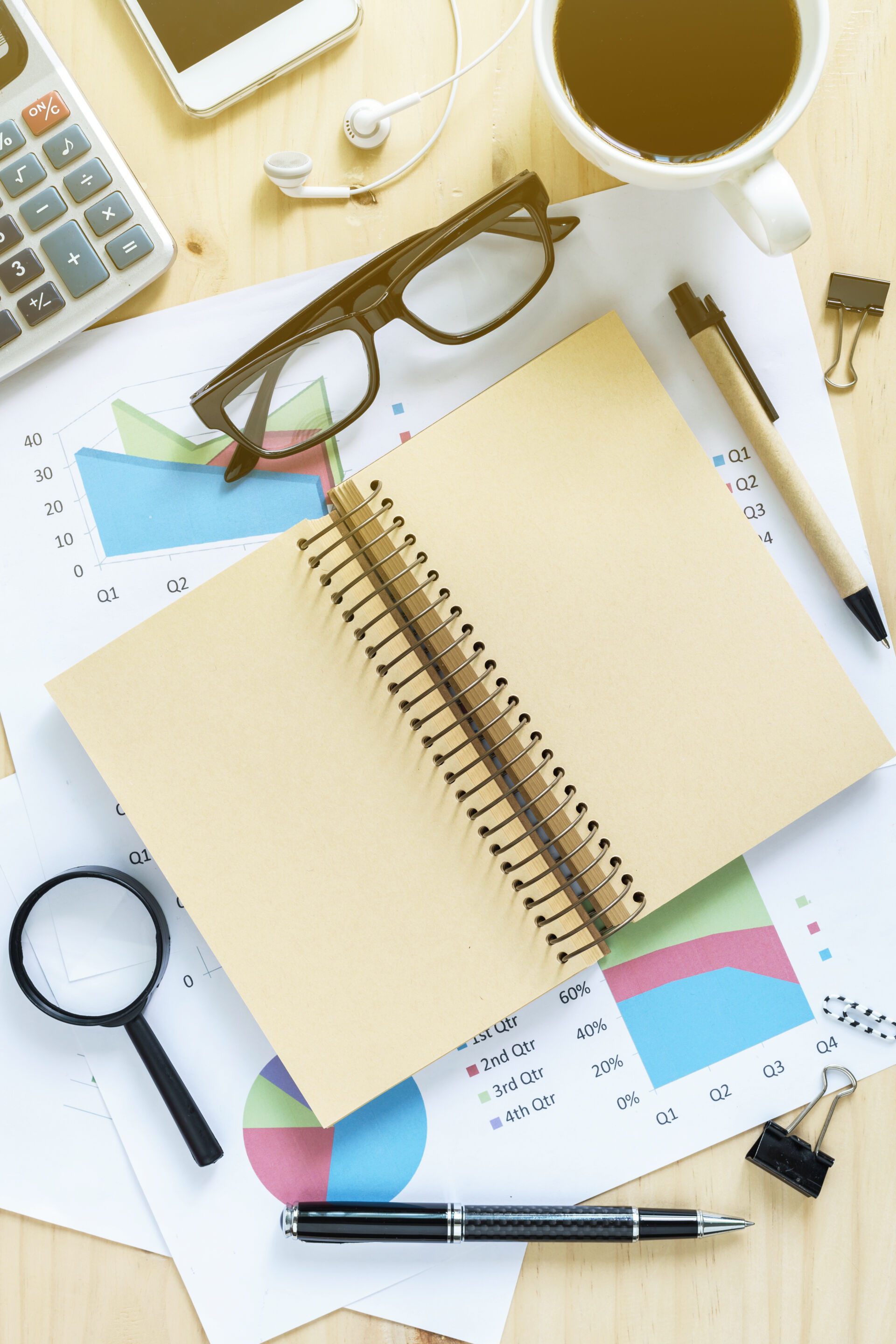 Blank notebook on Desk office, Business graph analysis with copy space demonstrating a business resource hub